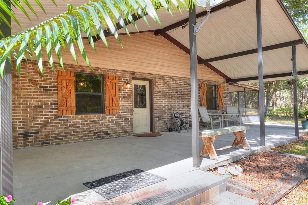 4846 Knights Station Road Lakeland, FL 33810 - Photo 3 of 49 a view of a patio with table and chairs near an umbrella