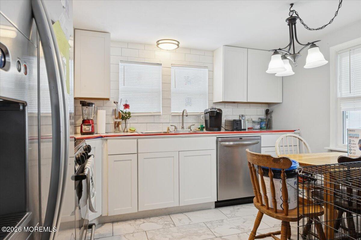 57 Roberts Road Toms River, NJ 08755 - Photo 12 of 14 a kitchen with stainless steel appliances a table chairs and a refrigerator