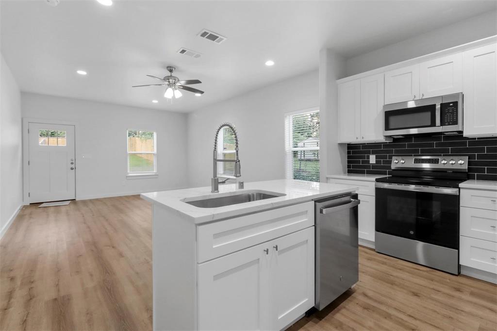 312 East Shepherd Street, Unit 312 Denison, TX 75021 - Photo 5 of 15 a kitchen with a sink stove and microwave