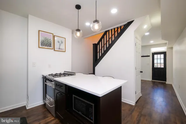a kitchen that has a sink a stove and a wooden floor