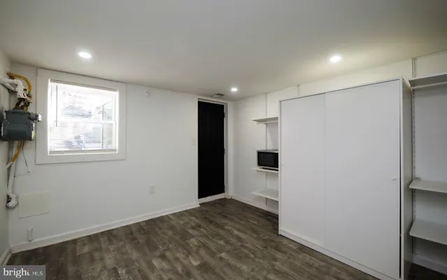 a view of empty room with wooden floor and window
