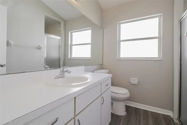 a bathroom with a sink a toilet and a window