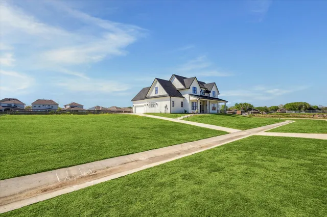 a view of a house with a big yard and potted plants