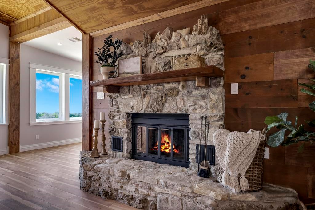 111 Stoney Hills Road Center Point, TX 78010 - Photo 19 of 61 a living room with a fireplace with wooden floor