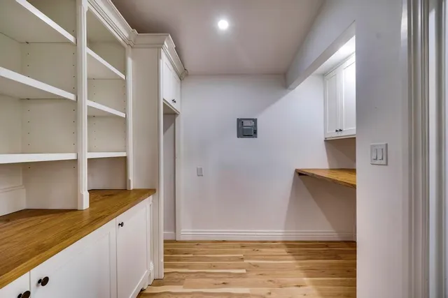 a view of empty room with wooden floor and fan