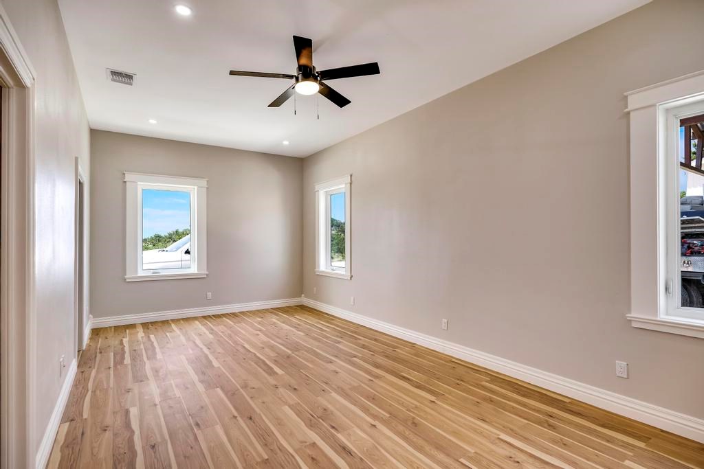 111 Stoney Hills Road Center Point, TX 78010 - Photo 37 of 61 wooden floor in an empty room with a window