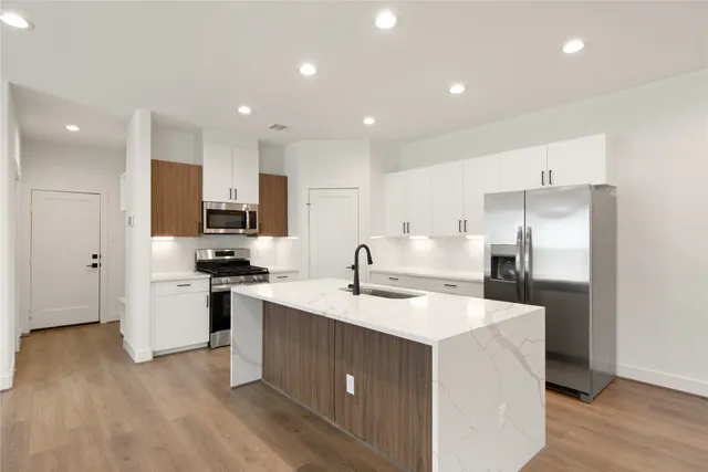 a kitchen with a sink a stove a refrigerator and a microwave