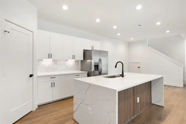 a kitchen with white cabinets appliances and sink