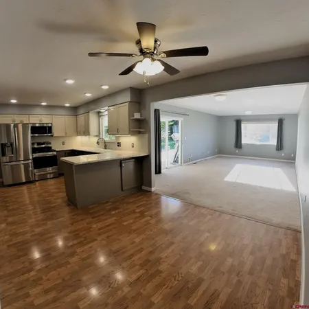 a kitchen with stainless steel appliances granite countertop a refrigerator a sink a stove a microwave and island