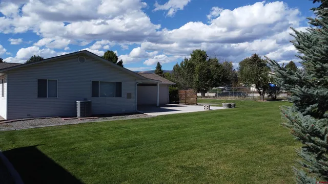 a house with green field in front of it