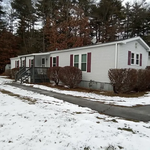 a front view of a house with a yard covered in snow