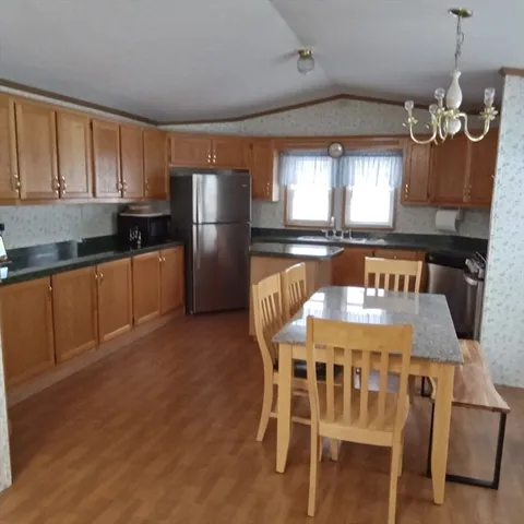 a kitchen with stainless steel appliances granite countertop a kitchen island hardwood floor sink stove dining table and chairs