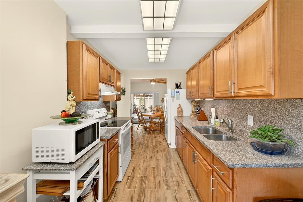 2064 Sunset Point Road, Unit 73 Clearwater, FL 33765 - Photo 20 of 58 a kitchen with lots of counter top space appliances and cabinets
