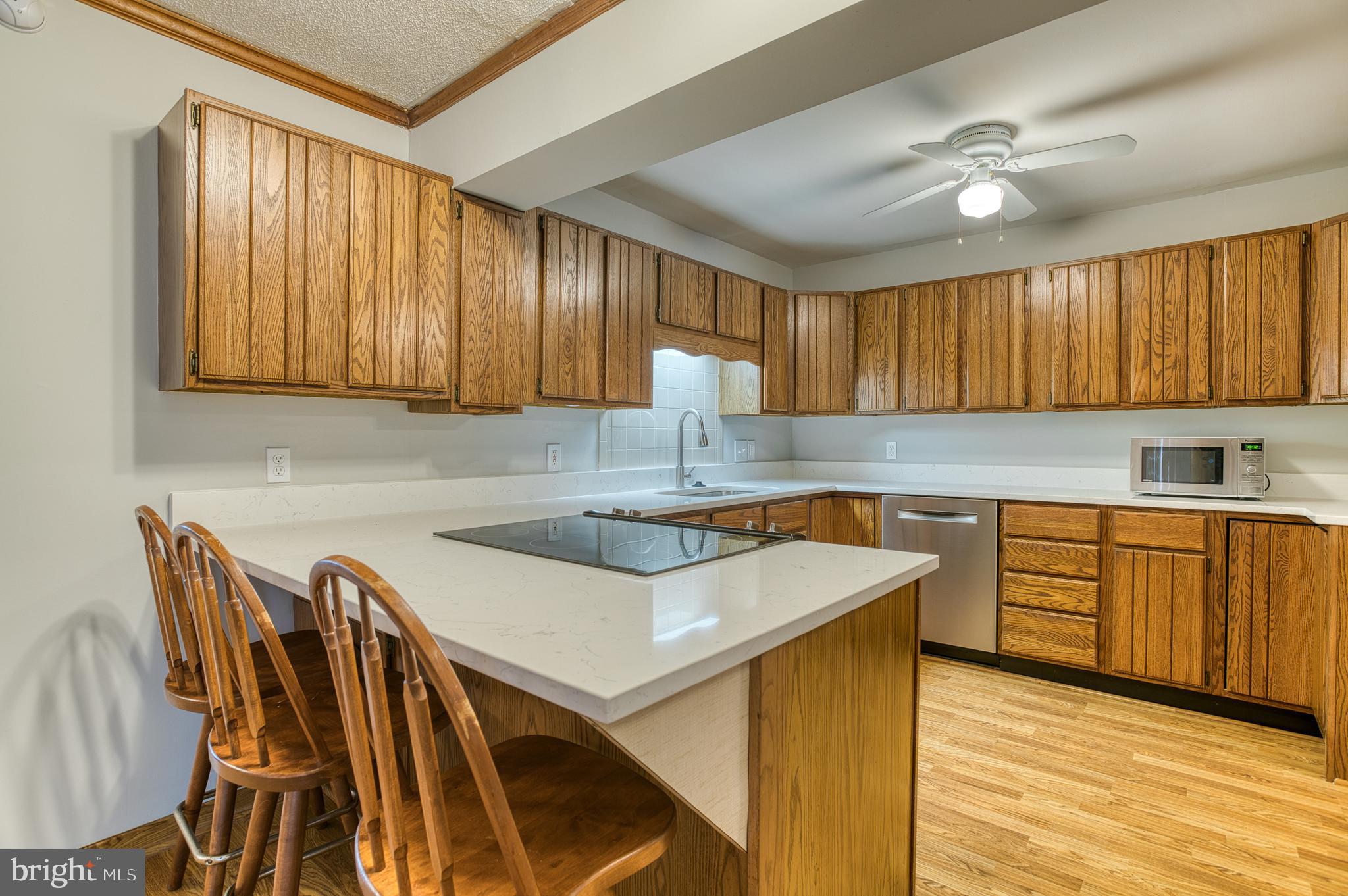 3565 Maple Street Dumfries, VA 22026 - Photo 11 of 36 a kitchen with kitchen island granite countertop wooden cabinets a sink and a stove