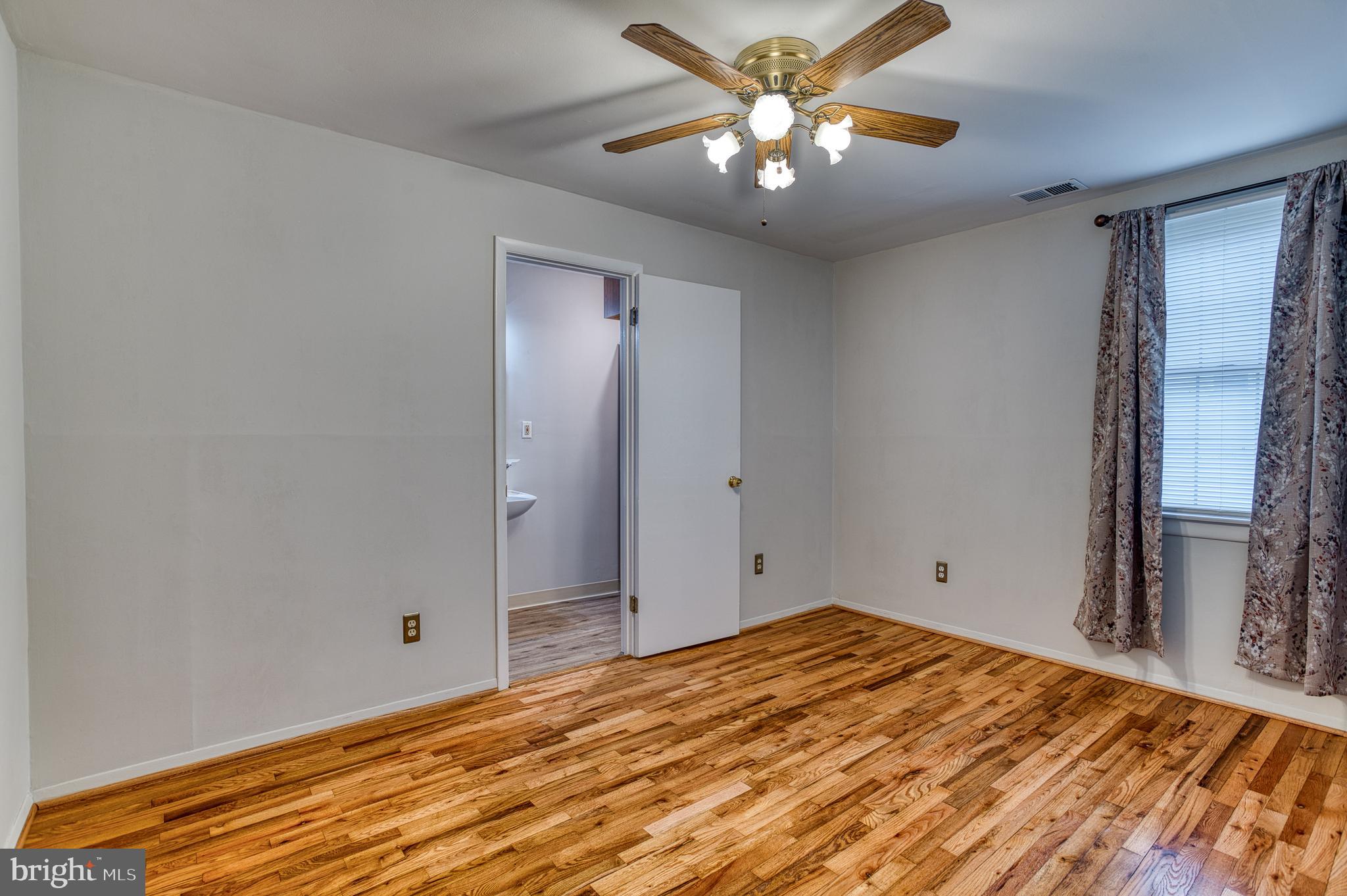 3565 Maple Street Dumfries, VA 22026 - Photo 4 of 36 a view of a big room with wooden floor and a chandelier fan