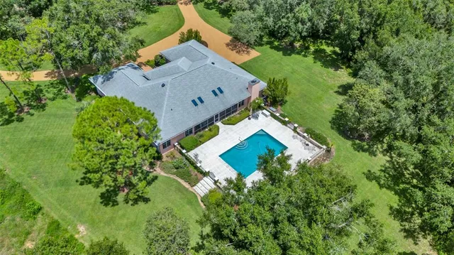 a room with stainless steel appliances kitchen island granite countertop a table chairs and a refrigerator