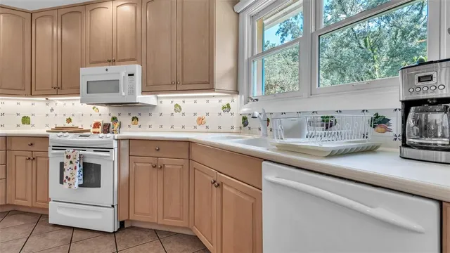 a bathroom with a double vanity sink and a mirror next to a window