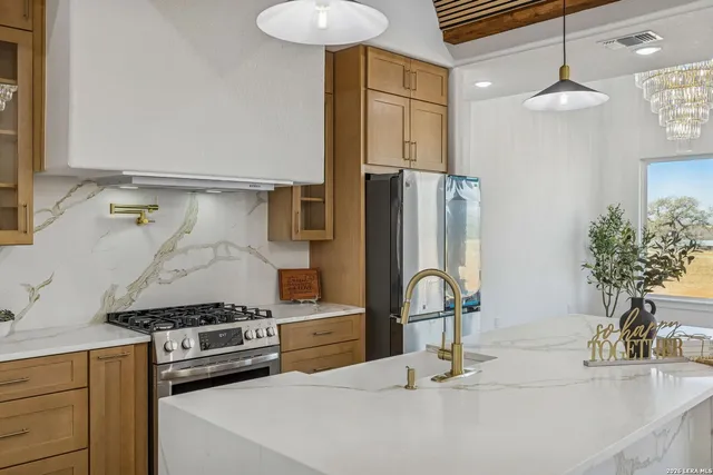 a kitchen with kitchen island a large counter top space and stainless steel appliances