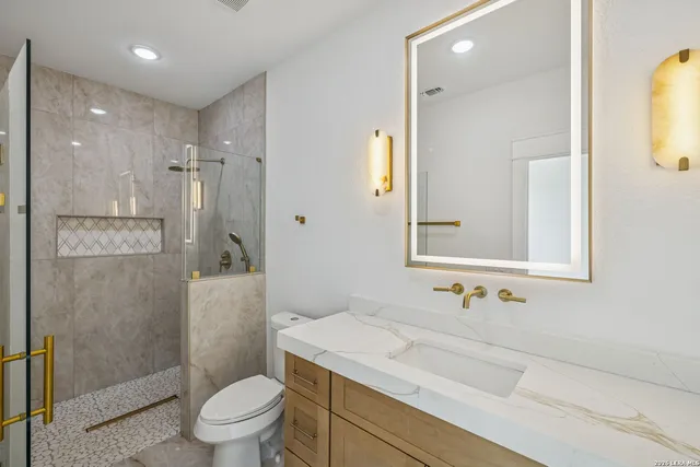 a bathroom with a sink a toilet and shower