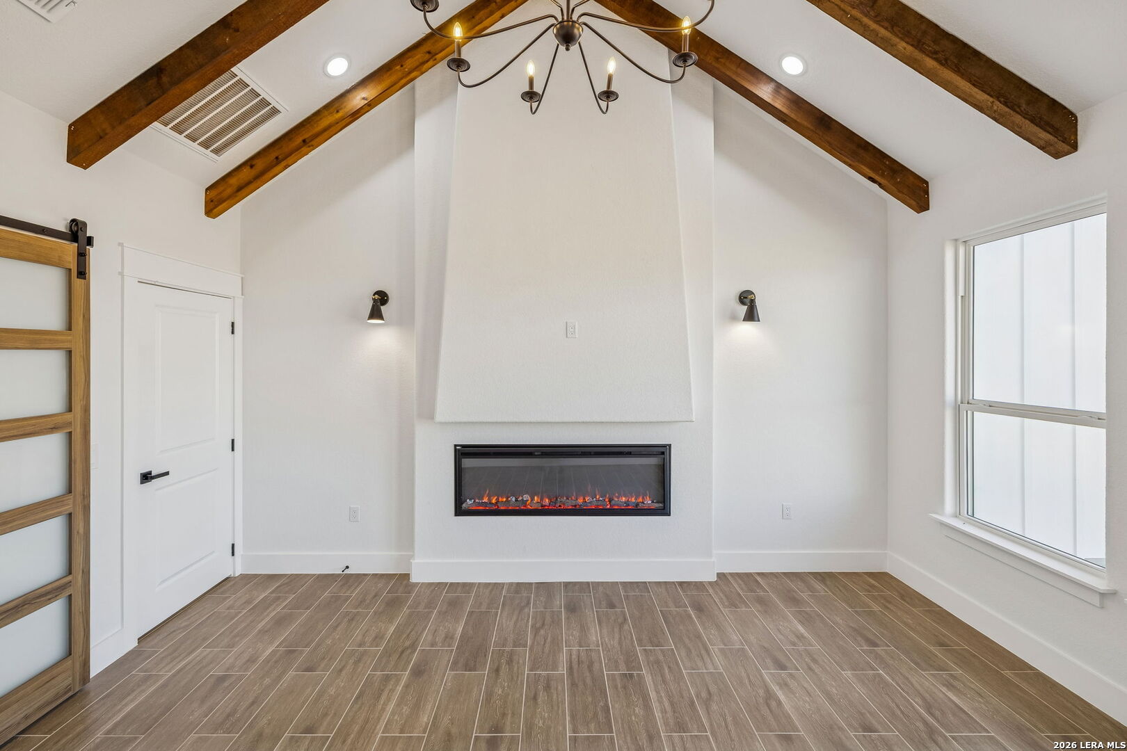 187 Hidden Ranch Court Floresville, TX 78114 - Photo 30 of 37 a view of an empty room with wooden floor fireplace and a window