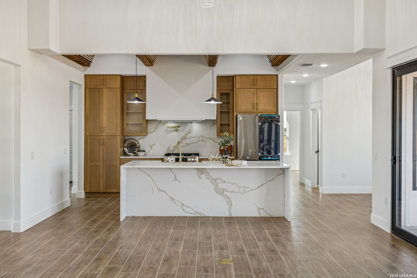 187 Hidden Ranch Court Floresville, TX 78114 - Photo 6 of 37 a living room with stainless steel appliances kitchen island granite countertop wooden floor and cabinets