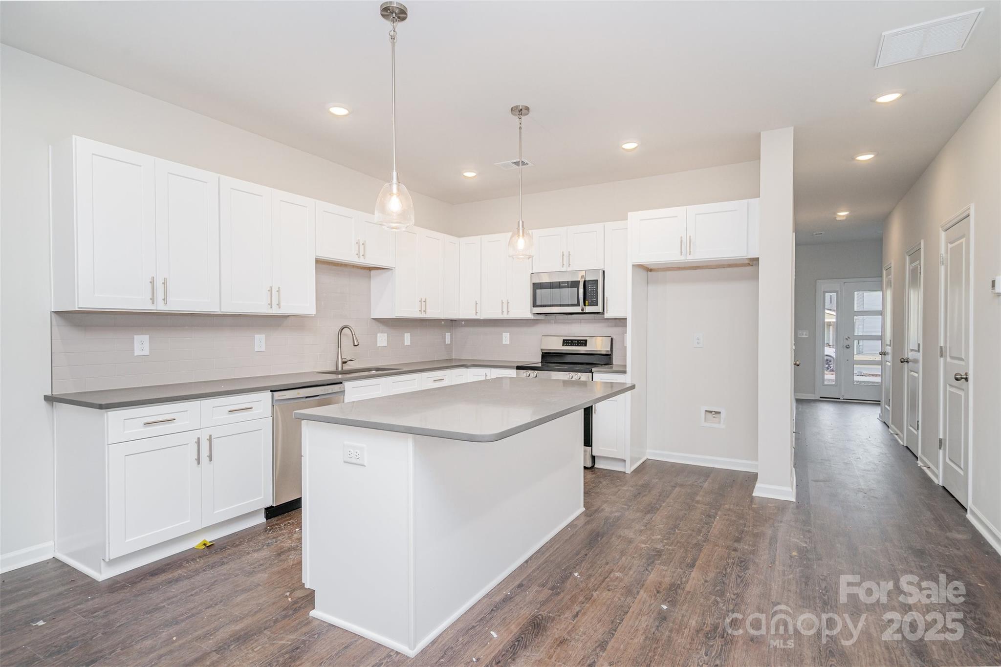 7312 Boswell Road Charlotte, NC 28215 - Photo 11 of 33 a kitchen with kitchen island a sink a stove a refrigerator and white cabinets