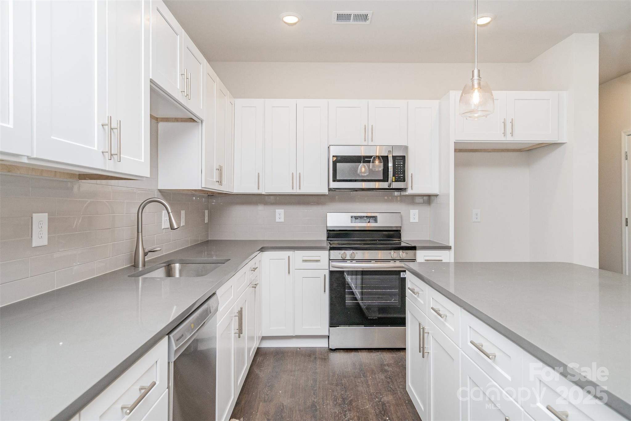 7312 Boswell Road Charlotte, NC 28215 - Photo 12 of 33 a kitchen with stainless steel appliances granite countertop a sink a stove top oven a counter space and cabinets
