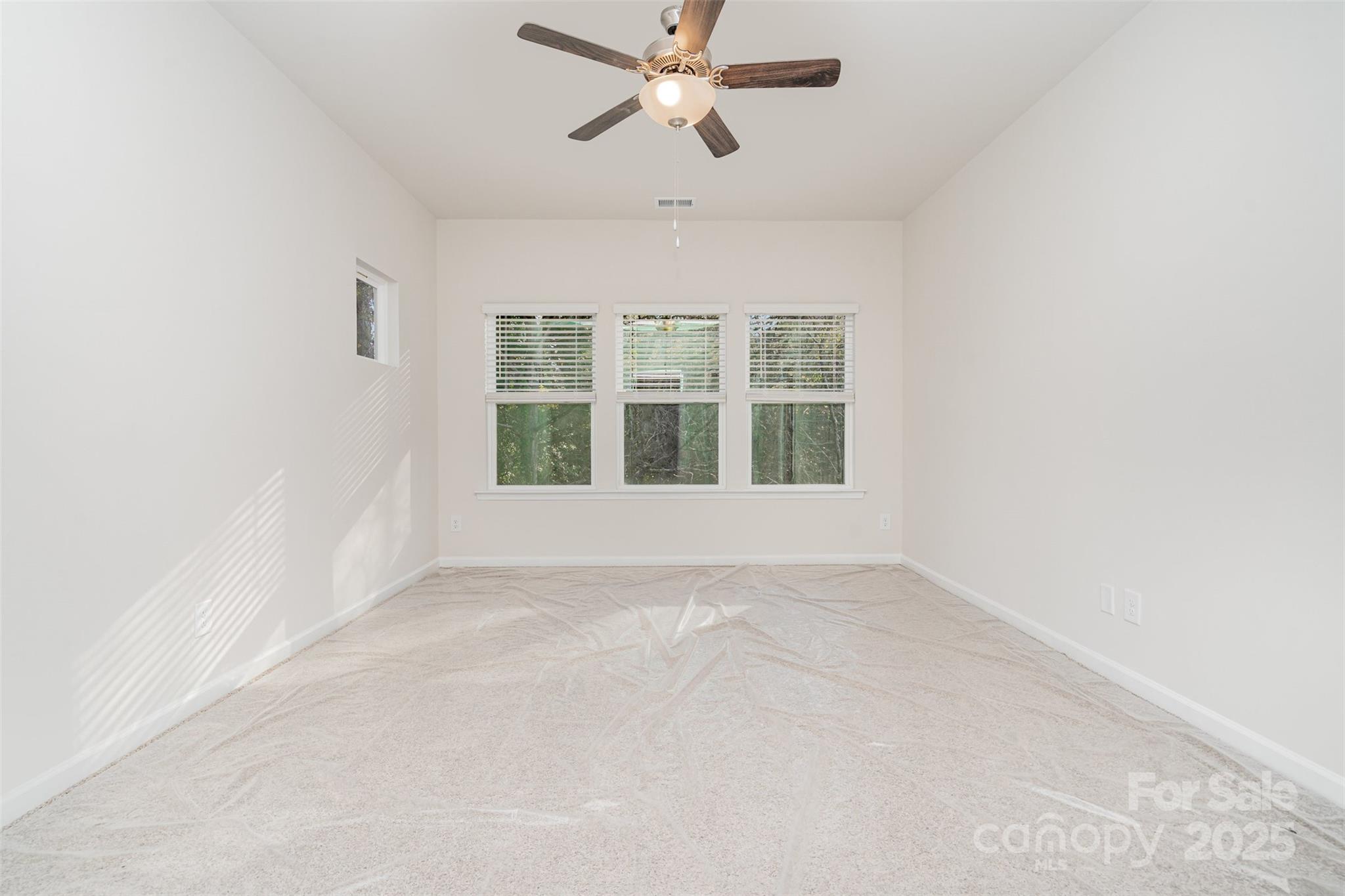 7312 Boswell Road Charlotte, NC 28215 - Photo 19 of 33 an empty room with chandelier fan and windows