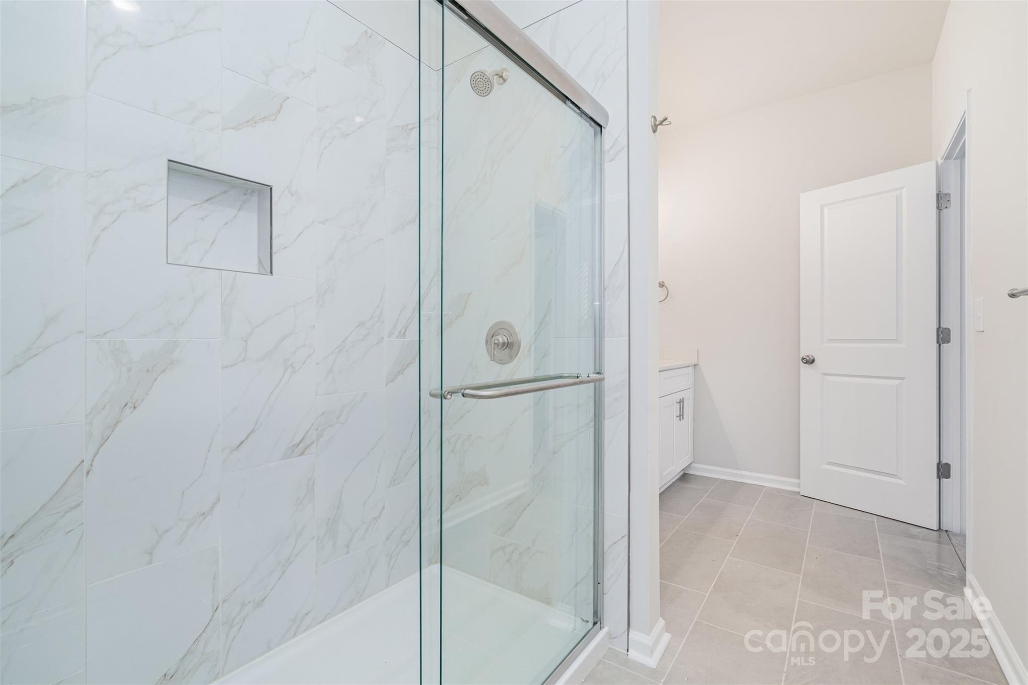 7312 Boswell Road Charlotte, NC 28215 - Photo 24 of 33 a bathroom with a glass shower door