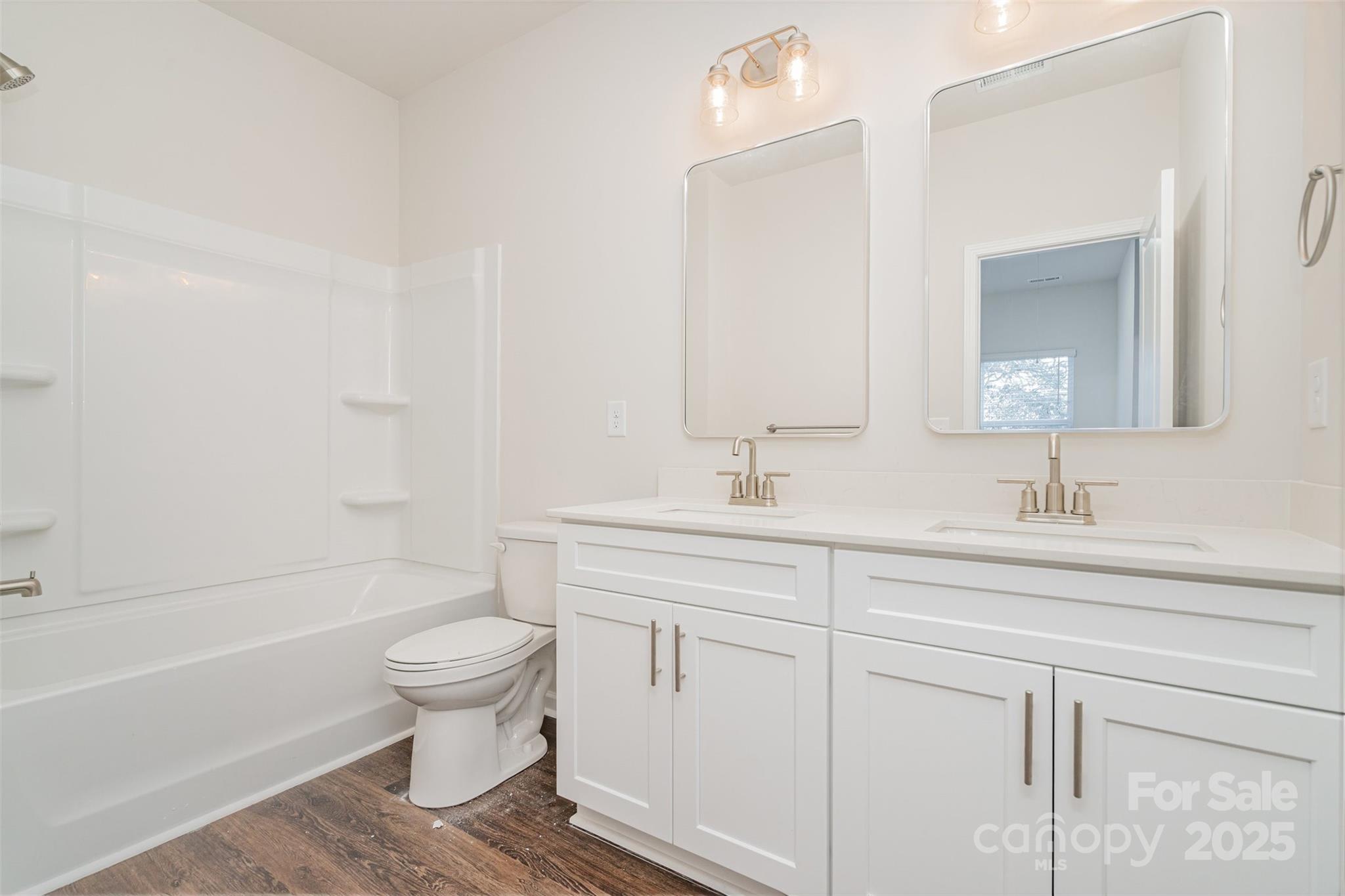 7312 Boswell Road Charlotte, NC 28215 - Photo 29 of 33 a bathroom with a toilet a sink a mirror a bathtub and vanity