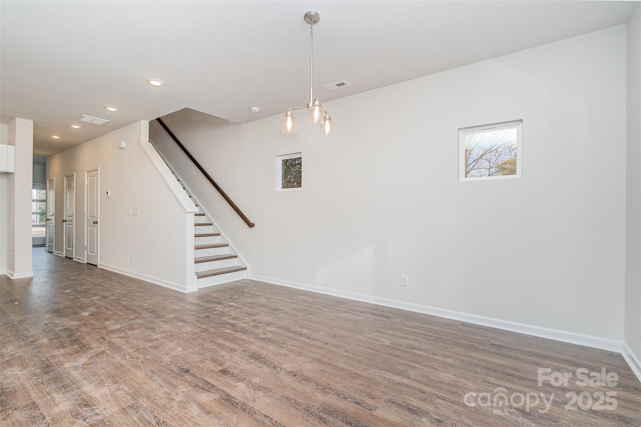 7312 Boswell Road Charlotte, NC 28215 - Photo 5 of 33 an empty room with wooden floor and staircase