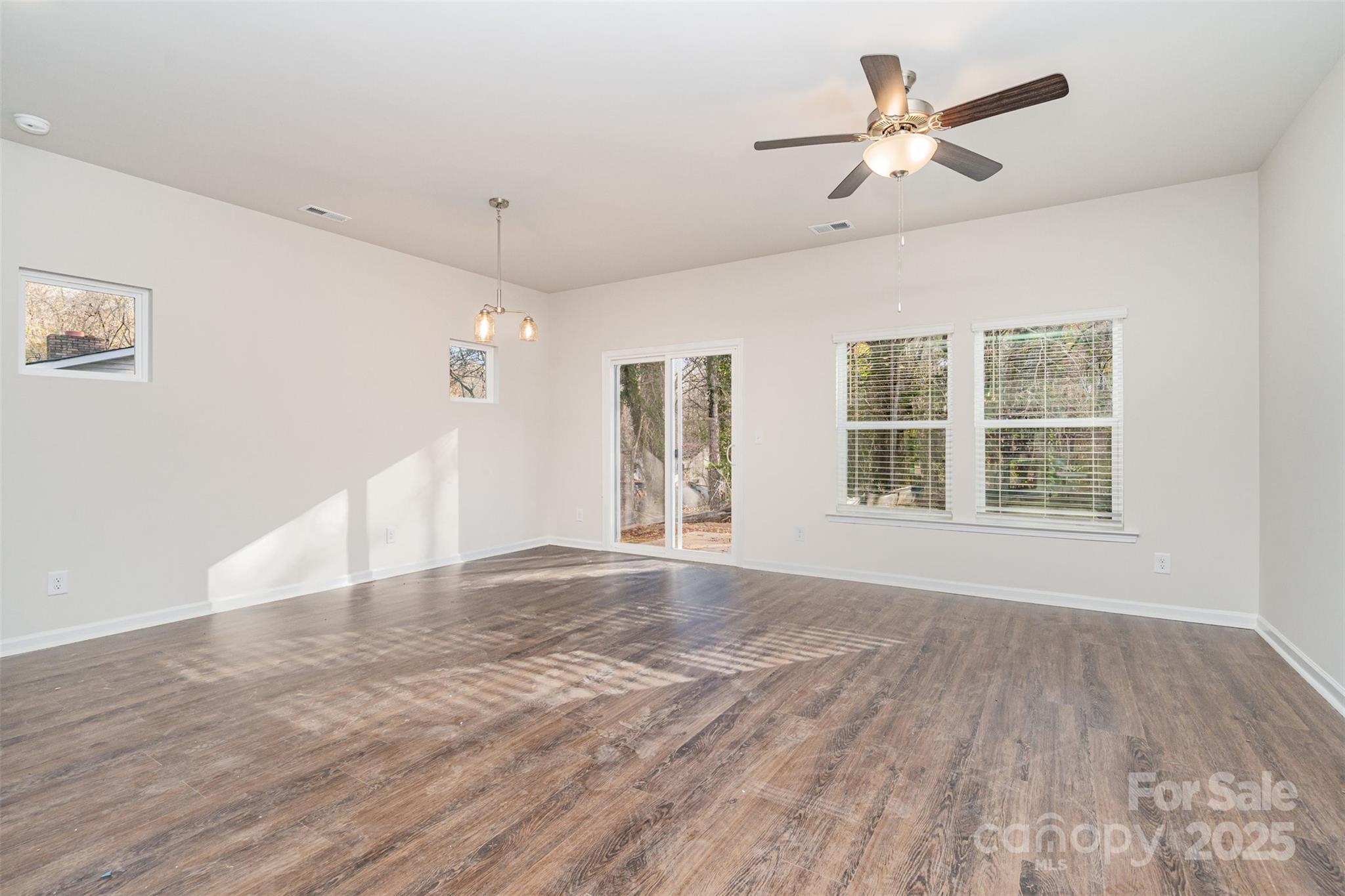 7312 Boswell Road Charlotte, NC 28215 - Photo 6 of 33 a view of an empty room with a window and wooden floor