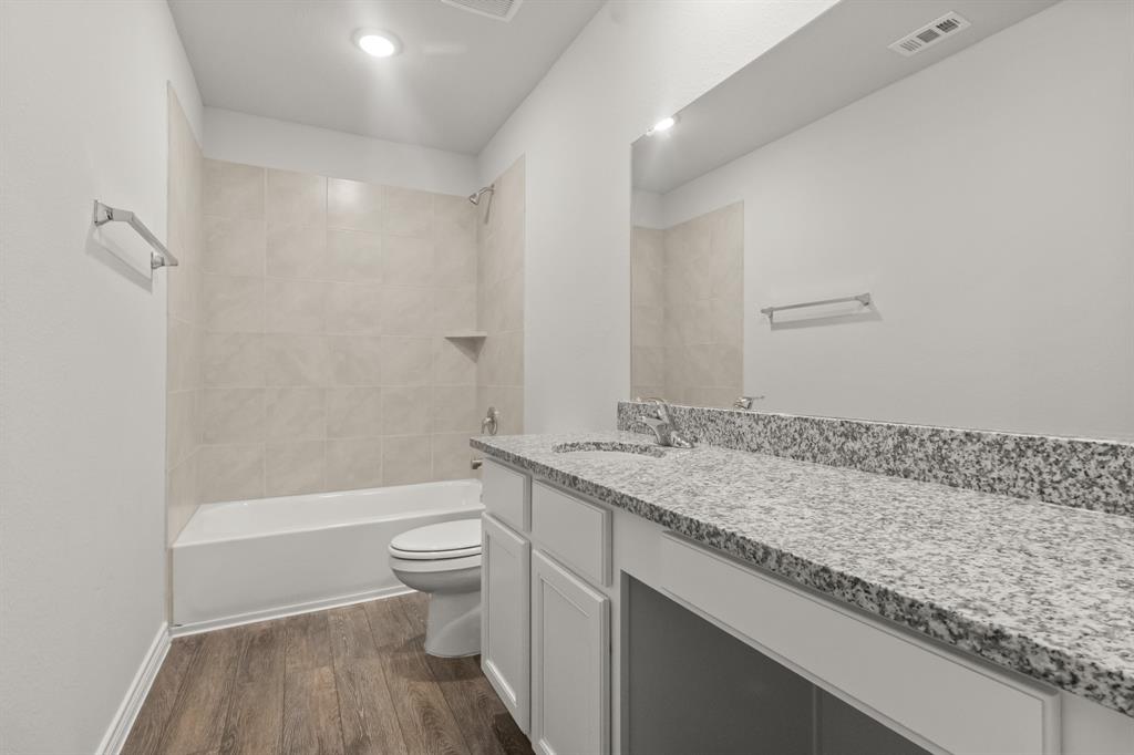 1609 Romans Road Ennis, TX 75119 - Photo 12 of 17 a bathroom with a granite countertop sink a toilet and shower