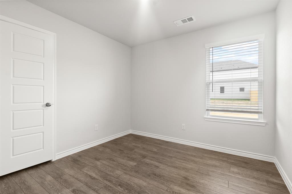 1609 Romans Road Ennis, TX 75119 - Photo 14 of 17 an empty room with wooden floor and windows