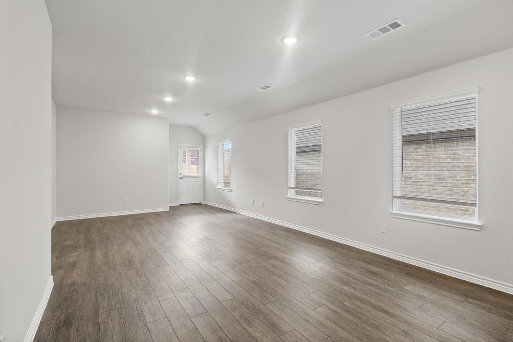 1609 Romans Road Ennis, TX 75119 - Photo 7 of 17 an empty room with wooden floor and windows