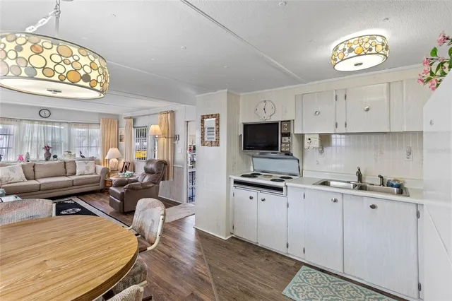 a view of kitchen with sink stainless steel appliances and living room view