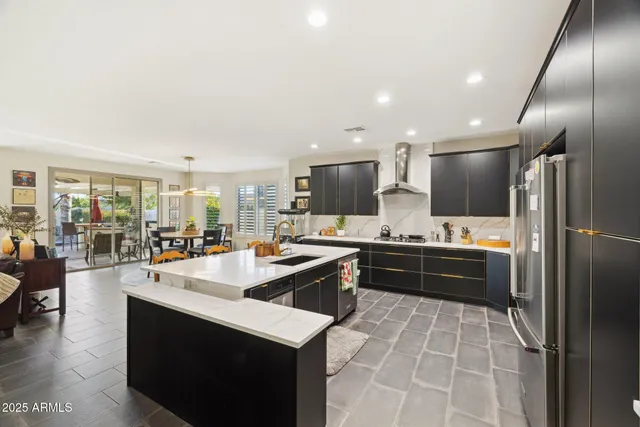 a large kitchen with kitchen island a sink a stove a dining table and chairs