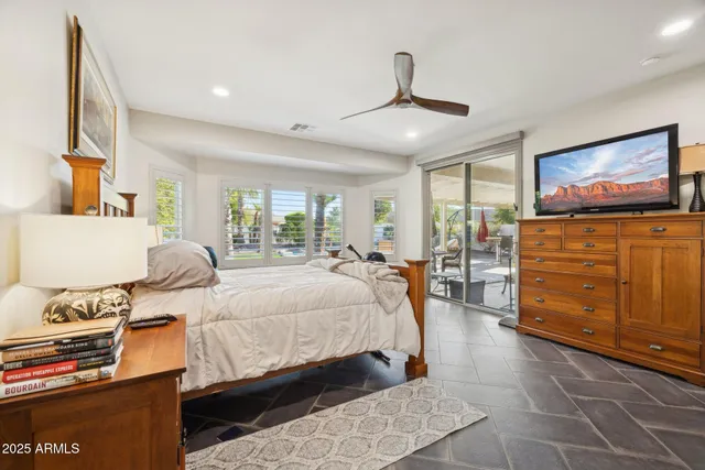 a bedroom with a large bed and a flat screen tv