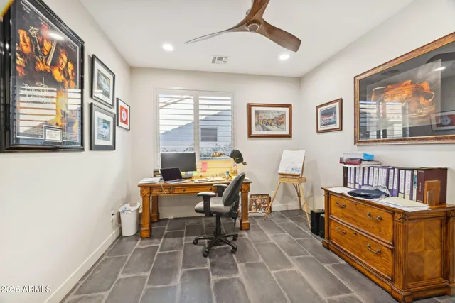 a work room with furniture a rug and a window