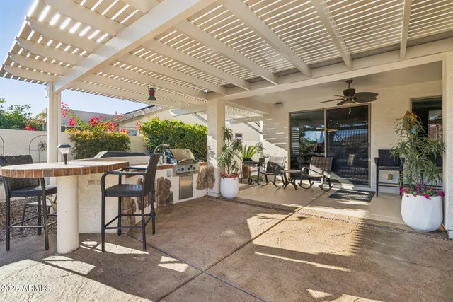 a view of a patio with a table and chairs under an umbrella
