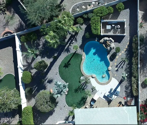 an aerial view of a house with large trees and plants