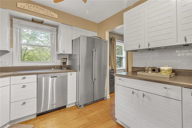 a kitchen with white cabinets and refrigerator