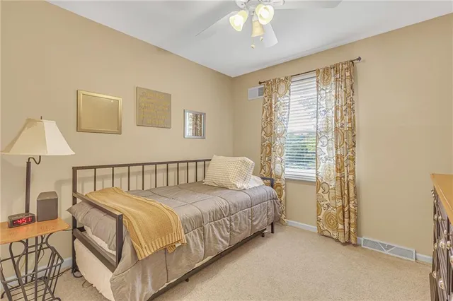 a bed sitting in a bedroom next to a lamp