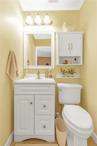 a bathroom with a granite countertop toilet sink and mirror