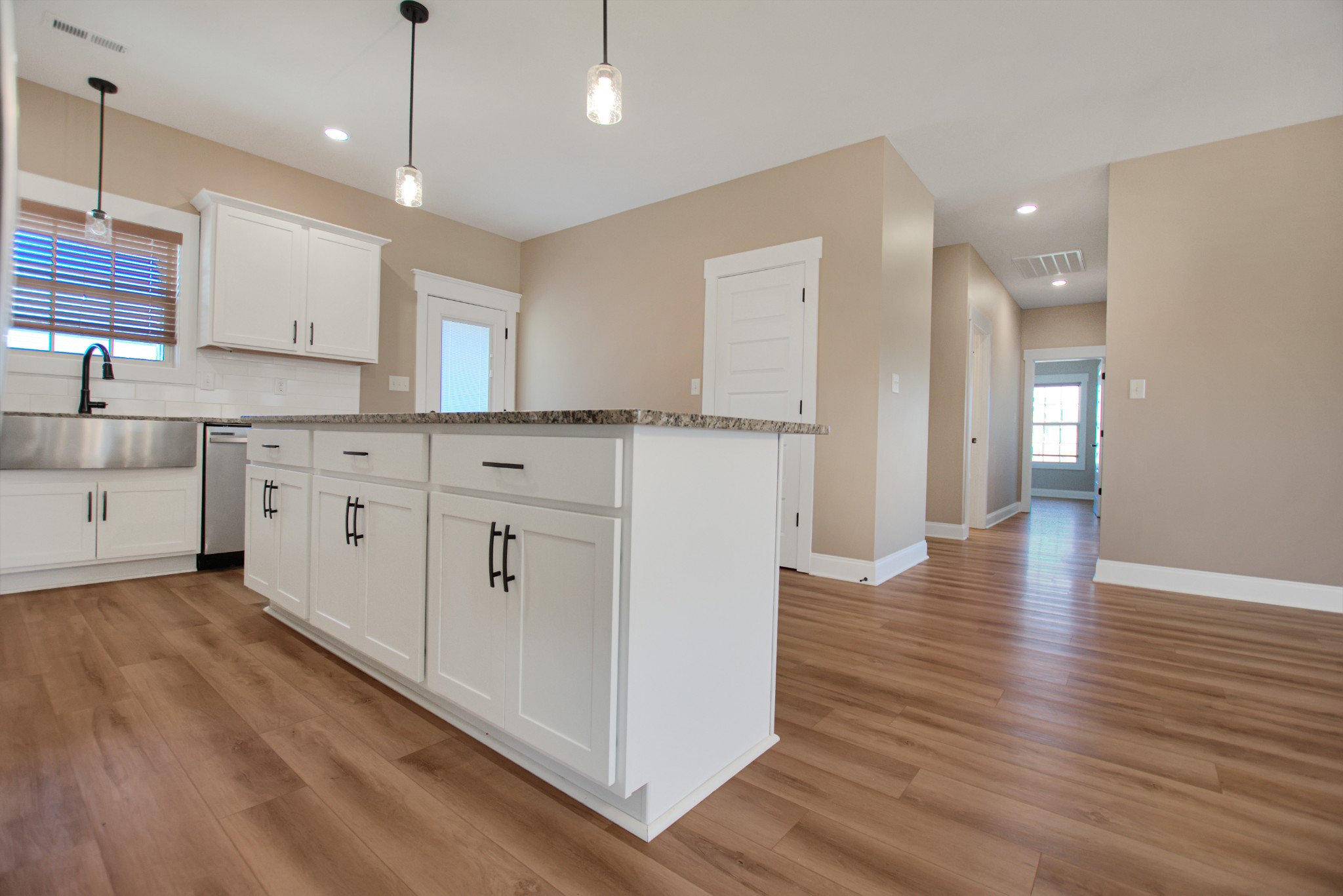 3495 Rabbit Run Trail Clarksville, TN 37043 - Photo 13 of 27 a view of a kitchen with stainless steel appliances granite countertop a refrigerator a sink dishwasher and white cabinets with wooden floor