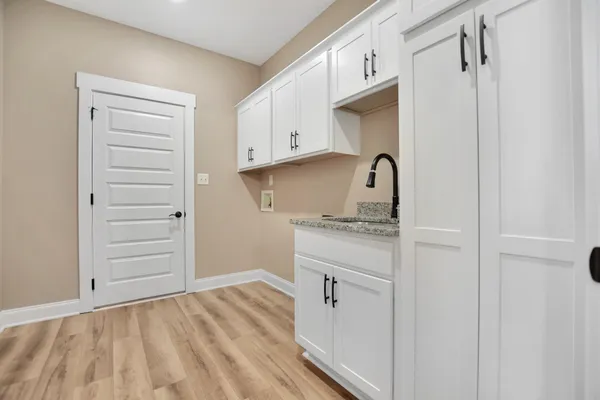 a kitchen with a sink cabinets and a wooden floor