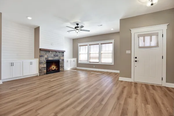 a view of empty room with wooden floor and fireplace