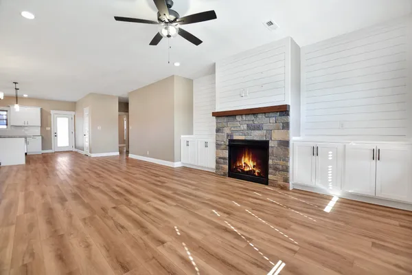a view of a room wooden floor fireplace and windows