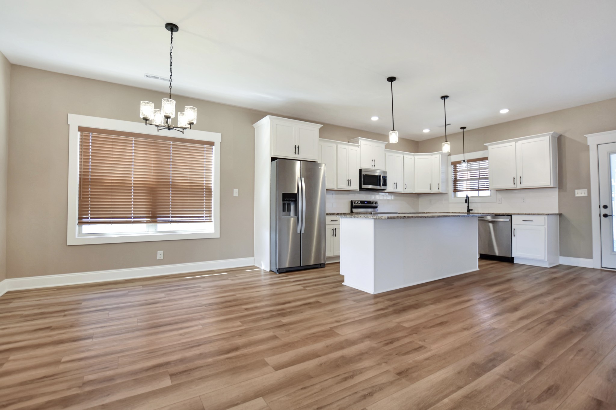 3495 Rabbit Run Trail Clarksville, TN 37043 - Photo 8 of 27 a open kitchen with stainless steel appliances granite countertop a refrigerator a oven a white stove a refrigerator and a fireplace with wooden floor