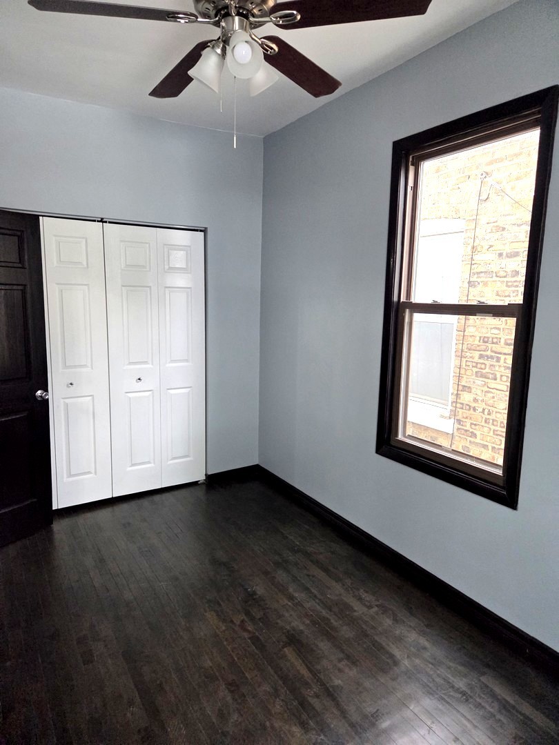 6324 South Francisco Avenue Chicago, IL 60629 - Photo 12 of 25 an empty room with wooden floor fan and windows